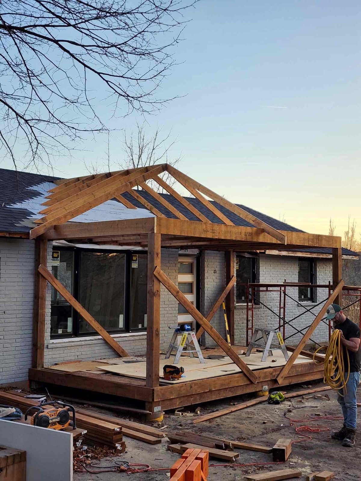 Timber-frame home addition under construction at sunset in Guelph